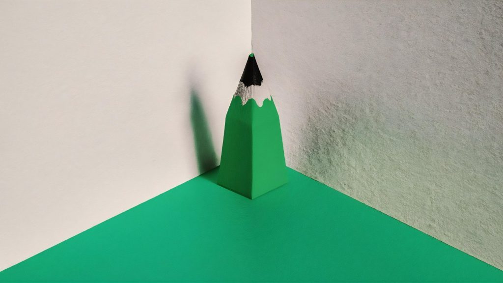 Close-up of a sharpened green pencil point, representing precision and brand edge